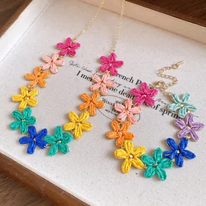 Detailed view of colorful raffia flower necklace and bracelet bohemian jewelry set