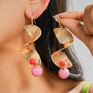 Detaillierte Nahaufnahme von goldenen Spiralohrringen mit rosa und roten Perlen