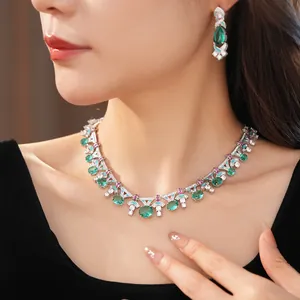 Detail view of luxury court style necklace with oval green zircons and enamel accents.