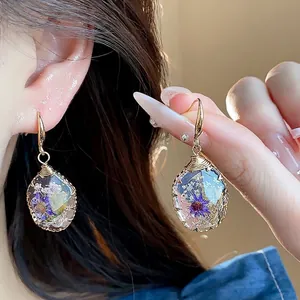 Elegant resin drop earrings with dried purple flowers and gold wire-wrapped hooks