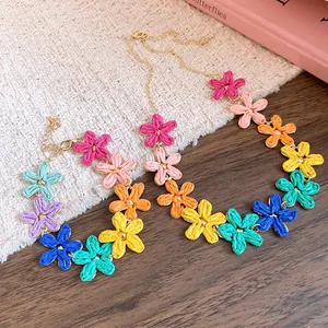 Detailed macro view of colorful hand-woven raffia flowers on a bohemian necklace chain.