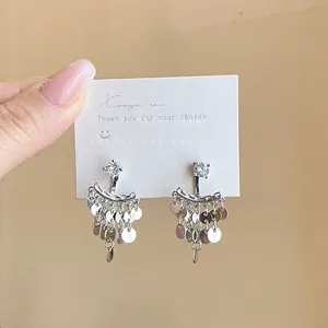 Detailed view of elegant silver sequin tassel earrings featuring a sparkling crystal stud