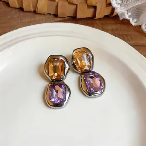 Detail view of French vintage silver needle stud earrings with amber and purple stones.