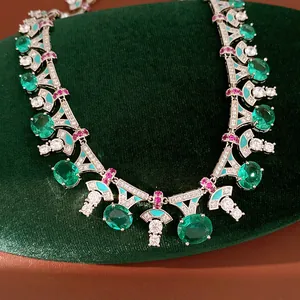 Detailed macro view of a luxury vintage emerald zircon necklace displayed on a green velvet stand