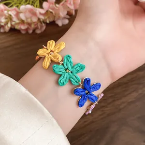 Macro view of colorful raffia flower bracelet on wrist featuring elegant woven texture