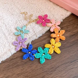 Close-up detail of a colorful bohemian raffia flower necklace for a sweet holiday look
