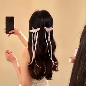Détail de pinces à cheveux nœud papillon rose avec glands sur une femme élégante