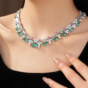 Detailed view of elegant palace-style necklace with green zircons worn by a female model