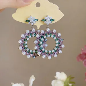 Detailed view of vintage oversized earrings featuring pink zircons and white pearls