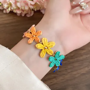 Detail view of colorful raffia flower charms on a bohemian style vacation necklace.