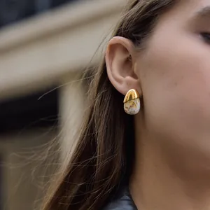 Detail view of a gold-plated stainless steel teardrop earring with resin marble pattern