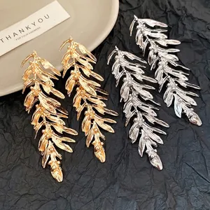 Elegant gold and silver metallic leaf feather tassel drop earrings on black backdrop