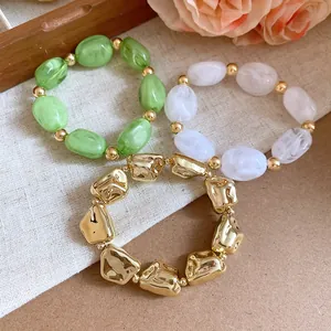 Detail of irregular geometric acrylic elastic bracelets in green white and gold