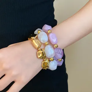 Detailed view of three irregular geometric acrylic stretch bracelets on a model wrist