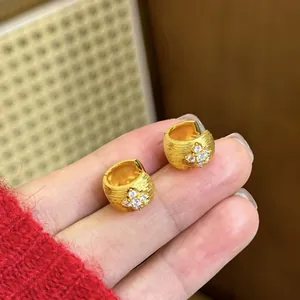 Detailed shot of 18k gold-plated hoop earrings with a sparkling zirconia cross design