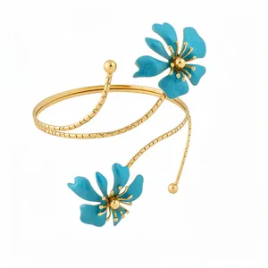 Elegant gold-plated spiral arm cuff with delicate blue enamel flower accents for women