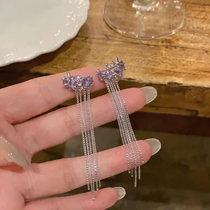 Detailed view of purple star ear cuffs with elegant long silver chain tassels in hand