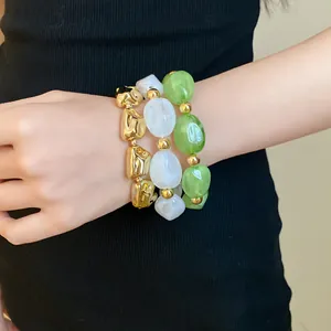 Elegant set of irregular acrylic elastic bracelets in green, white, and gold beads