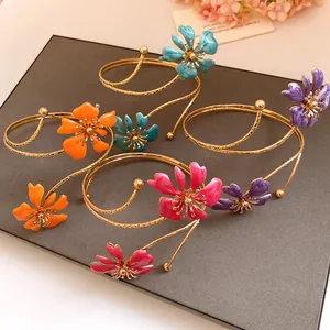 Macro view of colorful enamel flower arm cuff bracelets on a professional gray display board