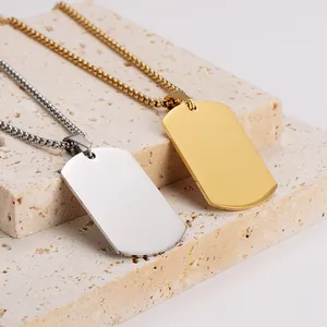 Macro detail of mirror-finish gold and silver stainless steel dog tag necklaces on stone
