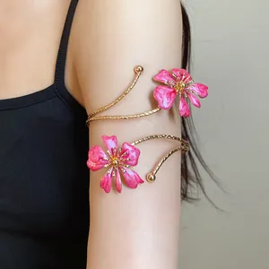 Detail shot of elegant pink enamel flower arm cuff bracelet on female model's arm