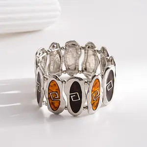 Macro detail of a vintage stretch bracelet featuring marbled resin and geometric engravings