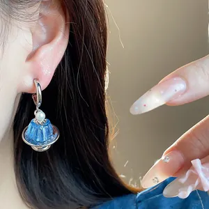 Detailansicht eines blauen Pudding-Ohrrings mit Perle und silbernem Creolen-Haken