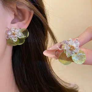 Detail shot of summer floral stud earrings with crushed stones and green shell accents
