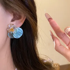 Close-up of summer style shell flower stud earrings worn on ear with sweet vacation vibe