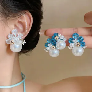 Detailed macro shot of French-style zircon and blue crystal pearl stud earrings