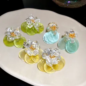 Detailed view of summer-style stone flower earrings with colorful circular shell pendants.