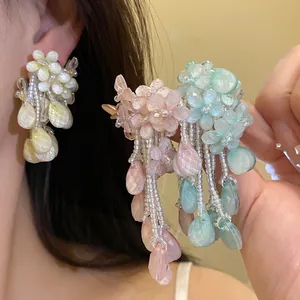 Detailansicht wunderschöner bunter Blumen-Perlenohrringe mit Quasten in Rosa Blau und Gelb.