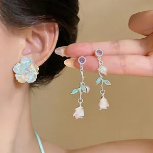Detailed view of French enamel rose earrings with pearls and purple zircon accents