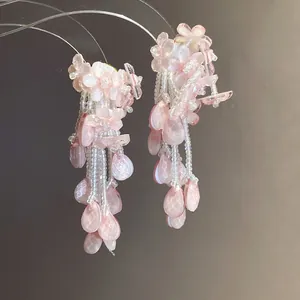 Detailansicht handgefertigter rosa Blumen-Ohrringe mit eleganten Tropfenkristallen.