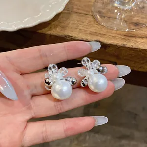 Macro view of French elegant pearl stud earrings with sparkling zircon and silver needles