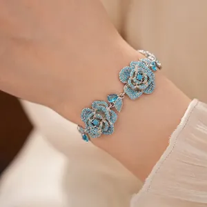 Vintage style zircon flower bracelet with turquoise blue stones on a model's wrist