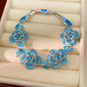Elegant vintage silver-toned bracelet with blue zircon flowers and leaf accents.