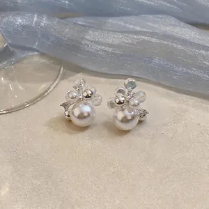 Detailed macro shot of French style pearl earrings with intricate crystal bead accents.