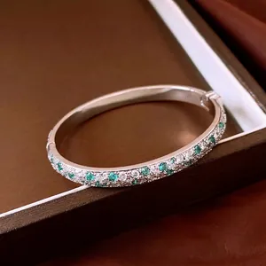 Elegant silver bangle encrusted with mint green and clear cubic zirconia stones
