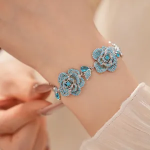Vintage style silver bracelet featuring exquisite blue zircon flower charms on wrist