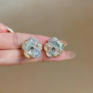 Close-up detail of elegant French-style rose stud earrings with iridescent glaze finish