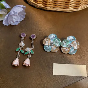 Detailed view of French style drip glaze rose drop earrings and pastel flower studs