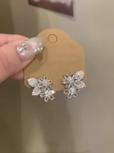 Eleganti orecchini a lobo floreali in zircone con cristalli scintillanti su carta kraft