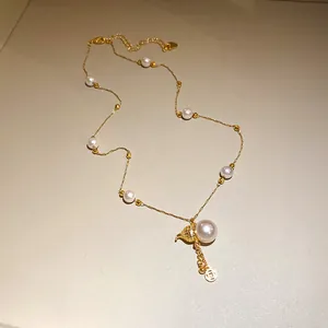Detail view of 14k gold plated necklace with pearl gourd pendant and lucky coin