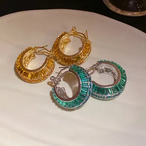 Dettaglio macro di orecchini a cerchio a C di lusso con zirconi colorati in stile vintage