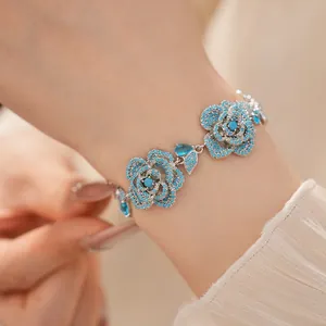 Vintage style silver flower bracelet with exquisite blue pavé stones shown on a wrist