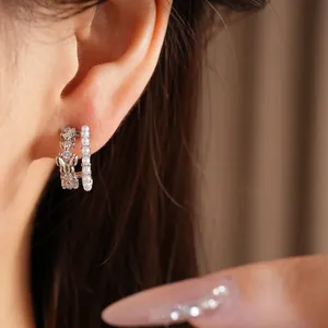 Detailed close-up showing a zircon butterfly pearl C-shaped earring worn on an earlobe