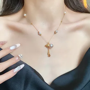Detail showing 14k gold plated necklace with elegant pearl gourd pendant on model's neck