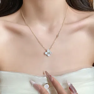 Close-up of 14k gold plated zircon flower pendant necklace on model's neck