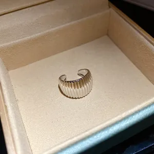 Detailed close-up of a silver ribbed ear cuff nestled in a premium velvet jewelry box.